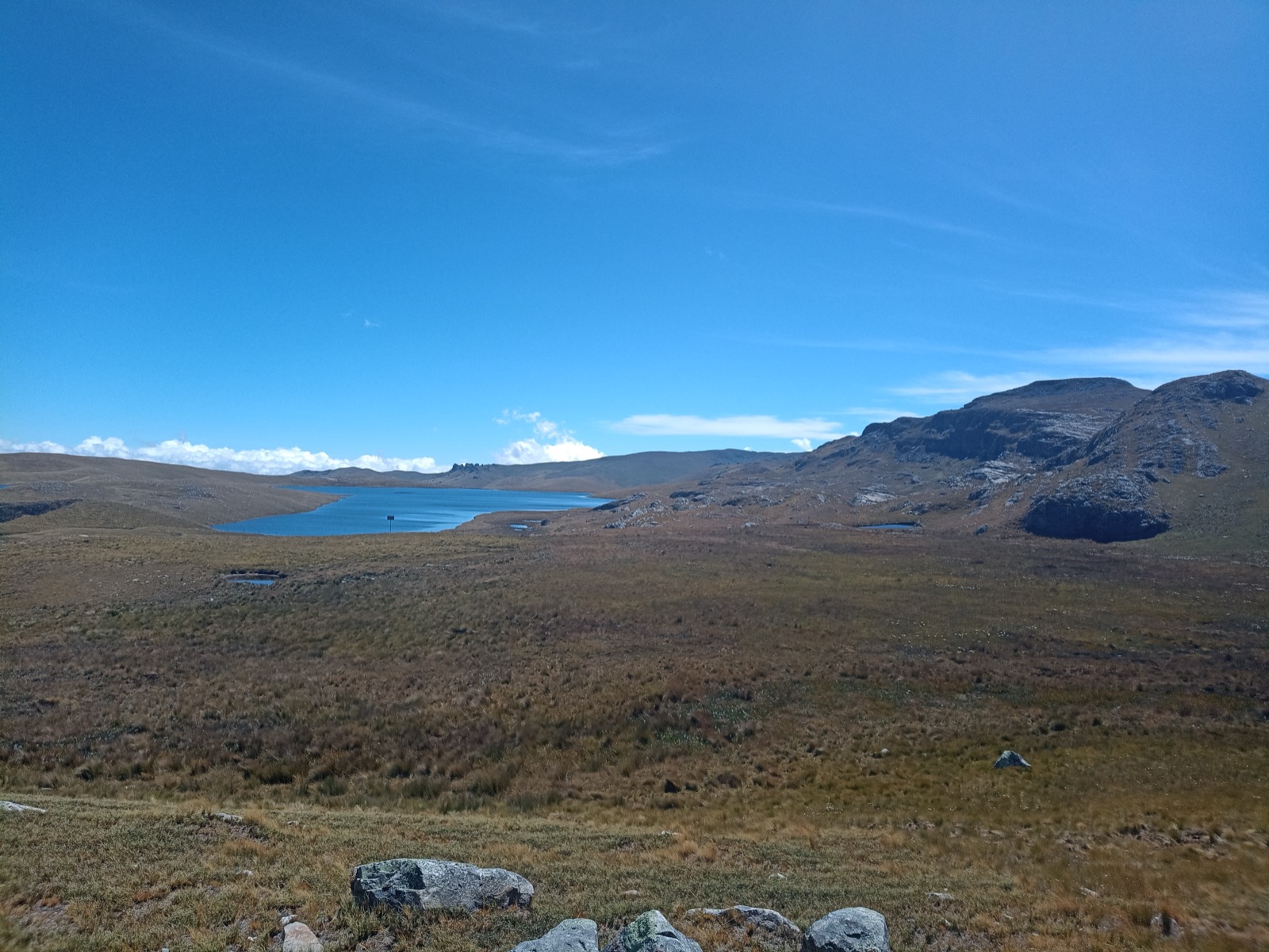 Two small lagoons lying in dark open moorland at Alto Perú, under a high clear sky